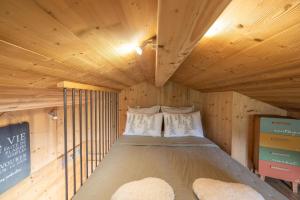 mały pokój z łóżkiem w drewnianej chacie w obiekcie Petit Chalet Cosy w mieście Combloux