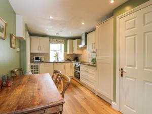 a kitchen with a wooden table and a wooden floor at The Suite in Thornhill +8 photos