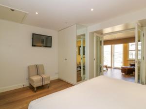 a bedroom with a bed and a chair and a television at The Suite in Thornhill