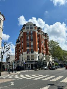een groot gebouw van rode baksteen in een stadsstraat bij Studio Metro Paris La-defense in Asnières-sur-Seine