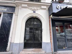 een gebouw met een zwarte deur met tralies bij Studio Metro Paris La-defense in Asnières-sur-Seine +2 foto's