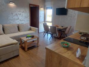 ein Wohnzimmer mit einer Couch und einem Tisch in der Unterkunft Apartman DIVČI TRON 11 in Divčibare