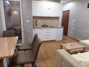 eine Küche und ein Wohnzimmer mit einer Couch und einem Tisch in der Unterkunft Apartman DIVČI TRON 11 in Divčibare
