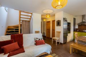 a living room with a white couch and a kitchen at Chalet 70 m2 - Risoul Village - à 15 mn des pistes in Risoul