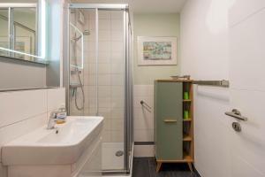 a bathroom with a sink and a shower at Ferienwohnung Kiel Water 4 in Schilksee