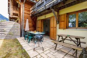 a patio with a grill and a table and benches at Chalet 70 m2 - Risoul Village - à 15 mn des pistes in Risoul