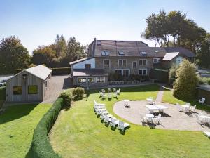 a large house with a yard with tables and chairs at Berismenil Gardens large villa with indoor swimming pool and jacuzzi in La Roche-en-Ardenne