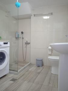 a bathroom with a shower and a washing machine at Enastron Cozy & Quiet Apartment in Heraklio +19 photos