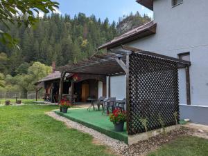 una casa con un patio con tavoli e sedie di Cazare La Piatra Buhei a Câmpulung Moldovenesc