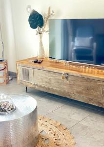 ein Wohnzimmer mit einem Holztisch und einem Spiegel in der Unterkunft Maison avec petite piscine Arcachon Bordeaux in Mios + 18 Fotos