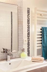 ein weißes Badezimmer mit Waschbecken und Spiegel in der Unterkunft Maison avec petite piscine Arcachon Bordeaux in Mios