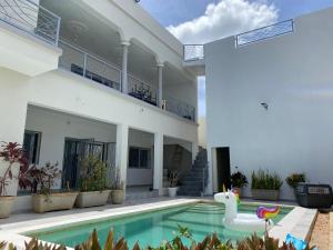 a house with a swimming pool with a swan in the yard at La villa Modibo in Ngaparou