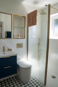 a bathroom with a shower and a toilet and a sink at Chevrons Living in Fordingbridge +30 photos