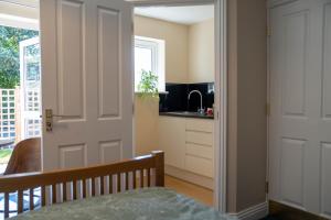 a kitchen with a door leading into a kitchen with a sink at Chevrons Living in Fordingbridge