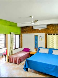 een slaapkamer met twee bedden en een bakstenen muur bij Yangzom Homez in Siliguri