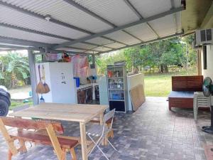 a patio with a wooden table and a refrigerator at River Farm Stay near beach w Fiber Optic and Netflix in Botolan