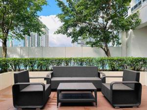 a patio with black chairs and a table and trees at Modern Suite In Bonifacio Global City in Manila