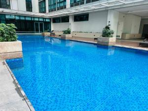 a large blue swimming pool in a building at Modern Suite In Bonifacio Global City in Manila