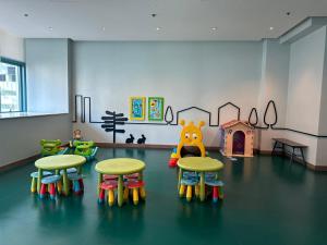 a room with three tables and chairs and a play area at Modern Suite In Bonifacio Global City in Manila