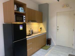 a kitchen with a black refrigerator and a microwave at Tranquil - Unit in Nuvali located at 5th floor w Balcony in Lagundi