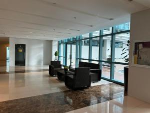 a lobby with couches and chairs in a building at Modern Suite In Bonifacio Global City in Manila +34 photos