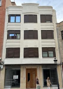 two women walking in front of a building at Apartamentos Casa Cabot - Rosario in Albacete
