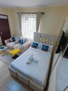 a bedroom with a large bed and a living room at Ravic Homes Studio in Nairobi