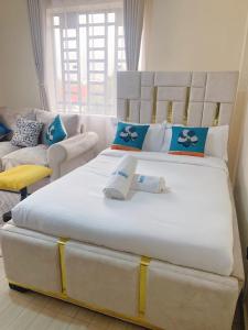a large bed with two pillows on it in a room at Ravic Homes Studio in Nairobi
