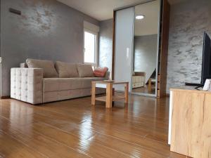una sala de estar con un sofá y una mesa en Apartmani DIVČI TRON 12, en Divčibare