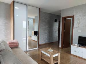 Una sala de estar con un sofá y un televisor. en Apartmani DIVČI TRON 12, en Divčibare