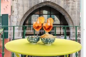 ジェノヴァにあるLusso, Doppio appartamento a 50 passi dal Duomoの黄色のテーブル(ワイングラス2杯、ボウル付)