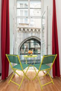 ジェノヴァにあるLusso, Doppio appartamento a 50 passi dal Duomoの窓の前にテーブルと椅子2脚