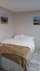 a bedroom with a white bed with a blanket on it at Tanchi Lica's Sunrise in Rooi Congo
