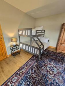 a bedroom with two bunk beds and a rug at Benroe House 5 Bedrooms in Killybegs