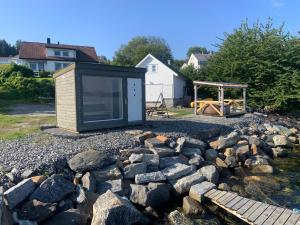 a tiny house sitting on top of a pile of rocks at Villa med sauna ute, egen båt, naust og kai in Breidvik +7 photos