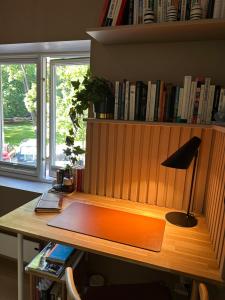 奥斯陆Groups & families, FREE parking, three bedrooms, two baths的一张带台灯的桌子和一个带书籍的书架