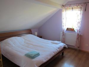 a white bed in a room with a window at Privat Vrbov 23 in Vrbov