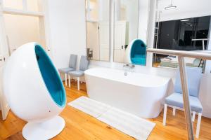 ein Badezimmer mit Badewanne, Waschbecken und Stühlen in der Unterkunft Premium Suites Vienna - Schönlaterngasse in Wien + 24 Fotos