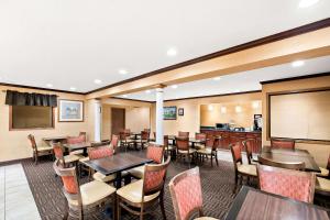 Un restaurante con mesas y sillas y una pizarra. en Quality Inn, en North Platte