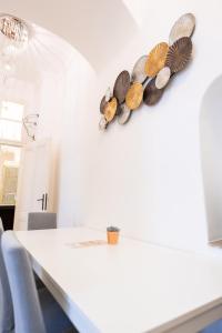 ein Esszimmer mit einem weißen Tisch mit Muscheln an der Wand in der Unterkunft Premium Suites Vienna - Schönlaterngasse in Wien
