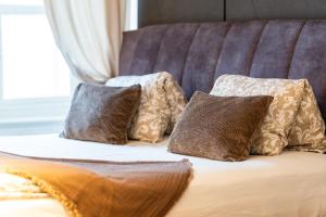 ein Bett mit vier Kissen darüber in der Unterkunft Premium Suites Vienna - Schönlaterngasse in Wien