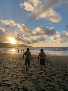 three men walking on the beach with their surfboards at The Wave Temple II in Las Palmas de Gran Canaria +13 photos