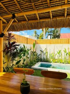 eine Terrasse mit einem Tisch und einem Swimmingpool von einem Haus in der Unterkunft Las Flores Lombok in Kuta Lombok