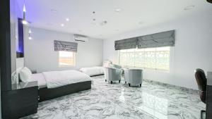 a bedroom with two beds and a table and two chairs at Marina Hotel in Sohar