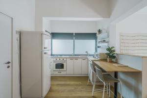 une cuisine blanche avec une table et un réfrigérateur dans l'établissement Nabi Yona Apartments, à Tel Aviv 28 autres photos