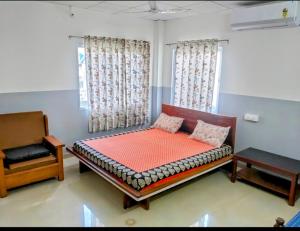 een slaapkamer met een bed en een stoel bij Yangzom Homez in Siliguri
