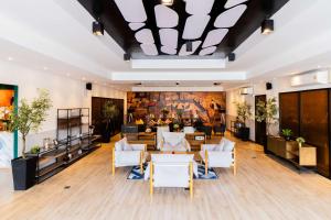 a lobby with white furniture and a painting on the wall at SureStay By Best Western Iconic Suvarnabhumi in Samut Prakan