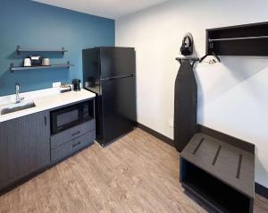 a kitchen with a black refrigerator and a sink at Studio 6 Corona, CA West in Corona