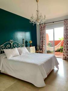 a bedroom with a white bed and a green wall at Apartamento en la Mesana en Sotogrande in Sotogrande