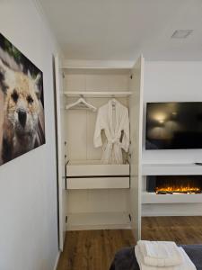 a dressing room with a white shirt and a fireplace at Grüne Stadtrandidylle - 22 min bis Potsdamer Platz in Berlin +8 photos